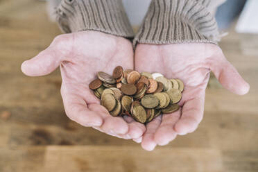 Close up of cupped hands with small change - KMKF01843