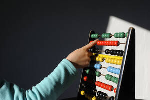 Boy calculating with colorful abacus at home - GISF00863