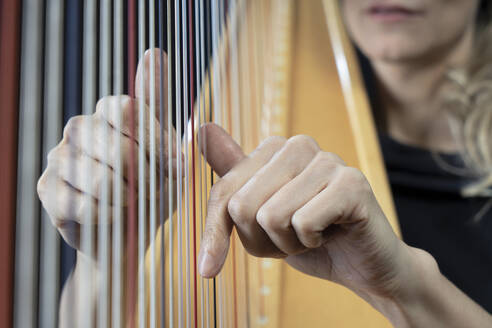 Hände einer reifen Frau spielen Harfe - RNF01355