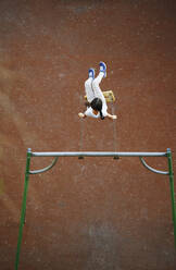 Playful girl enjoying on swing at playground - AZF00401