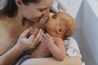 Smiling mother rubbing nose with son in bathtub at home - MFF09097