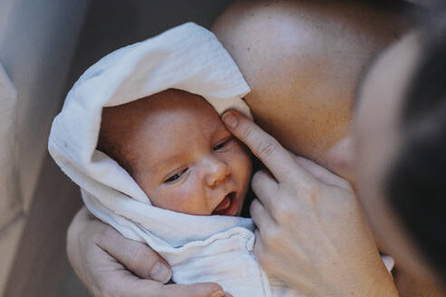 Mother holding baby wrapped in towel - MFF09099