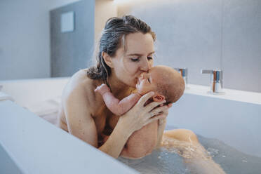 Frau küsst kleinen Jungen in der Badewanne zu Hause - MFF09107
