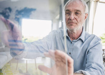 Freelancer using futuristic transparent screen at home - UUF26097