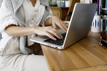 Hands of businesswoman using laptop at home - TYF00177