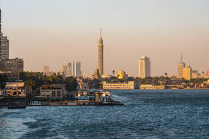 Ägypten, Kairo, Pier im Stadtteil Gezira in der Abenddämmerung mit Cairo Tower und Skyline der Innenstadt im Hintergrund - TAMF03355