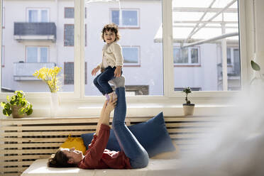 Mother and daughter sitting on sofa - JOSEF09409