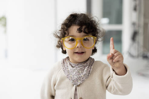 Cute little girl wearing oversized eyeglasses raising finger - JOSEF09481