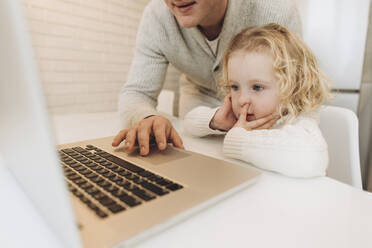 Cute daughter with father using laptop at home - SIF00109