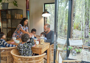 Familie isst am Esstisch in der Hütte - CAIF32421