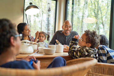 Happy family eating at dining table - CAIF32424