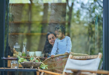 Mother and daughter at dining table - CAIF32432