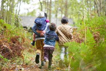 Brüder und Schwester wandern auf einem Pfad im Wald - CAIF32433