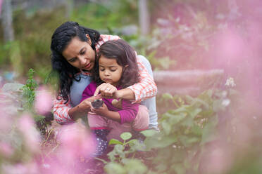 Mother and toddler daughter gardening - CAIF32441
