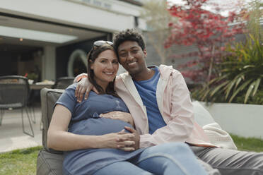 Portrait happy pregnant couple on patio - CAIF32490