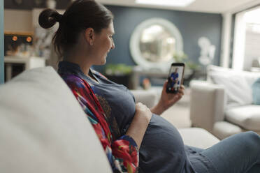 Schwangere Frau im Video-Chat mit Arzt auf Smartphone - CAIF32511