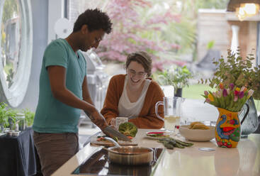 Glückliches Paar beim Kochen in der Küche - CAIF32512