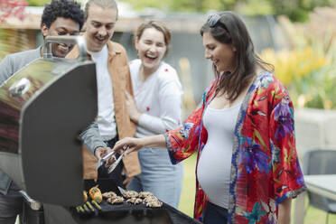 Freunde beim Grillen von Gemüse auf der Veranda - CAIF32519