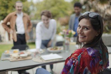 Portrait happy woman enjoying lunch with friends at patio table - CAIF32524