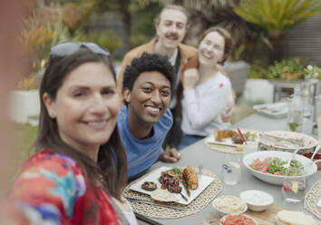 Portrait happy couple friends enjoying lunch at patio table - CAIF32535