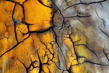 Voller Rahmen abstrakten Hintergrund der strukturierten Erde mit getrockneten Boden und verschiedene schwarze Risse Schaffung von Mustern auf gelb und braun Oberfläche - ADSF34706