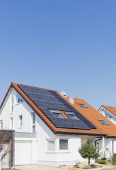 Deutschland, Nordrhein-Westfalen, Solarmodule auf Ziegeldächern eines modernen Vorstadthauses - GWF07398