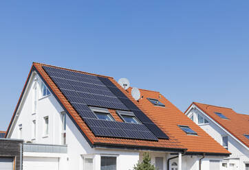 Deutschland, Nordrhein-Westfalen, Solarmodule auf Ziegeldächern eines modernen Vorstadthauses - GWF07403
