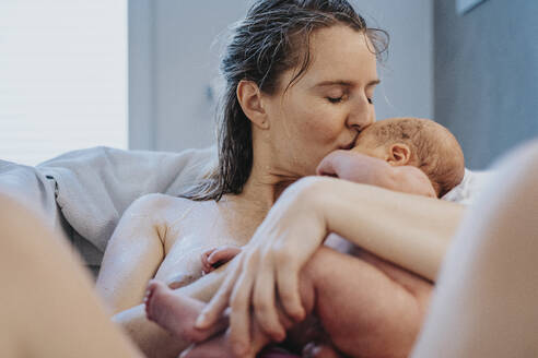 Mother kissing son's forehead in bathtub - MFF09112