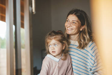 Smiling mother with daughter seen through window - JOSEF09531