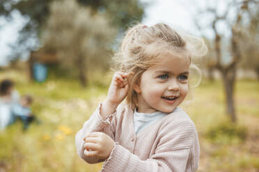 Smiling cute blond girl standing in meadow - JOSEF09544