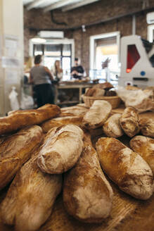 Baguettes arranged on table in bakery - JUBF00388