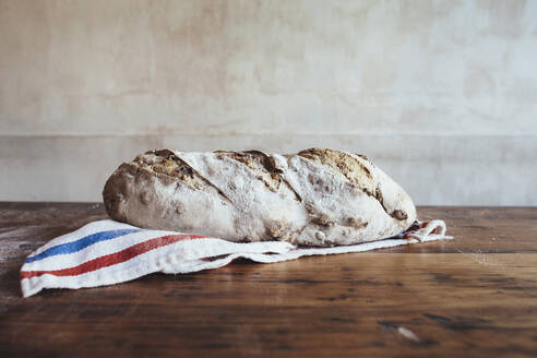 Frisch gebackenes Landbrot auf einer Serviette in einer Bäckerei - JUBF00404