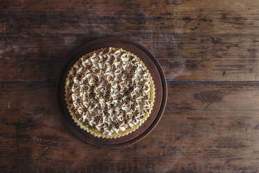 Fresh meringue cake on wooden table in bakery - JUBF00413