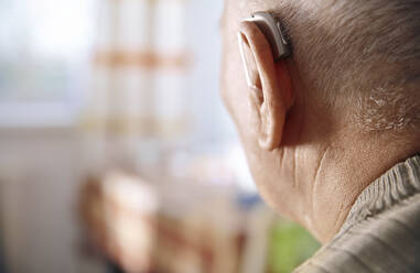 Ear of senior man with hearing aid - AZF00406