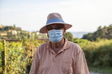 Älterer Tourist mit Hut und Gesichtsschutzmaske - MAMF02241