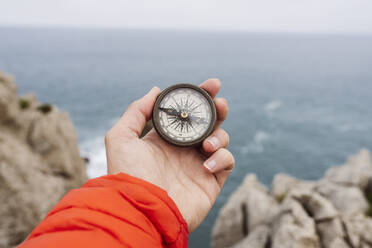 Die Hand eines Mannes hält einen Navigationskompass - JCCMF06321