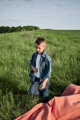 Junge mit Fernglas auf einem landwirtschaftlichen Feld am Wochenende - ZEDF04543