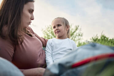 Mutter spricht mit Tochter beim Picknick auf einem Feld - ZEDF04548