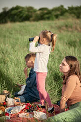 Mutter und Kinder beim Picknick auf einem landwirtschaftlichen Feld - ZEDF04559
