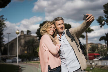 Lächelndes Paar nimmt Selfie auf Smartphone in der Stadt - JOSEF09584