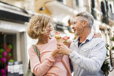 Smiling couple with ice cream cones - JOSEF09605