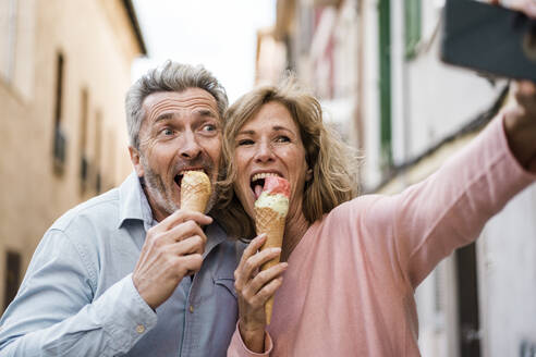 Glückliche Touristen essen Eis und machen ein Selfie mit ihrem Smartphone - JOSEF09612