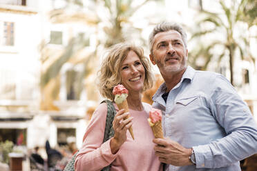 Happy woman with ice cream by man in city - JOSEF09660