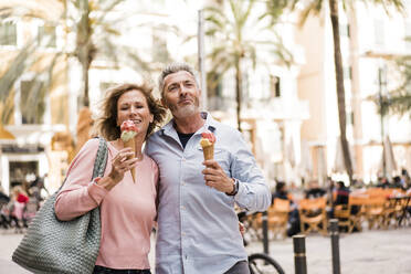Mature couple enjoying ice cream in sidewalk cafe - JOSEF09661
