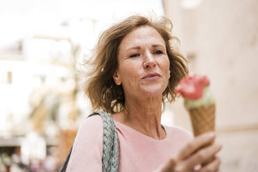 Mature woman holding ice cream cone - JOSEF09662