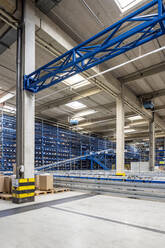 Cardboard boxes by conveyor belt in warehouse - PESF03817