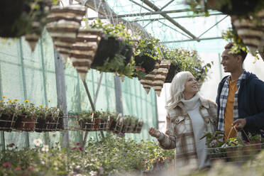 Glückliches Paar beim Einkaufen von Pflanzen in einem Gartengeschäft - CAIF32564