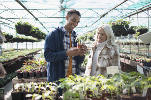 Glückliches Paar beim Einkaufen von Topfpflanzen in einem Gartengeschäft - CAIF32601