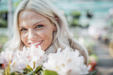 Close up portrait happy woman with flowers - CAIF32603