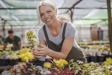 Portrait happy female garden shop owner with plants - CAIF32618